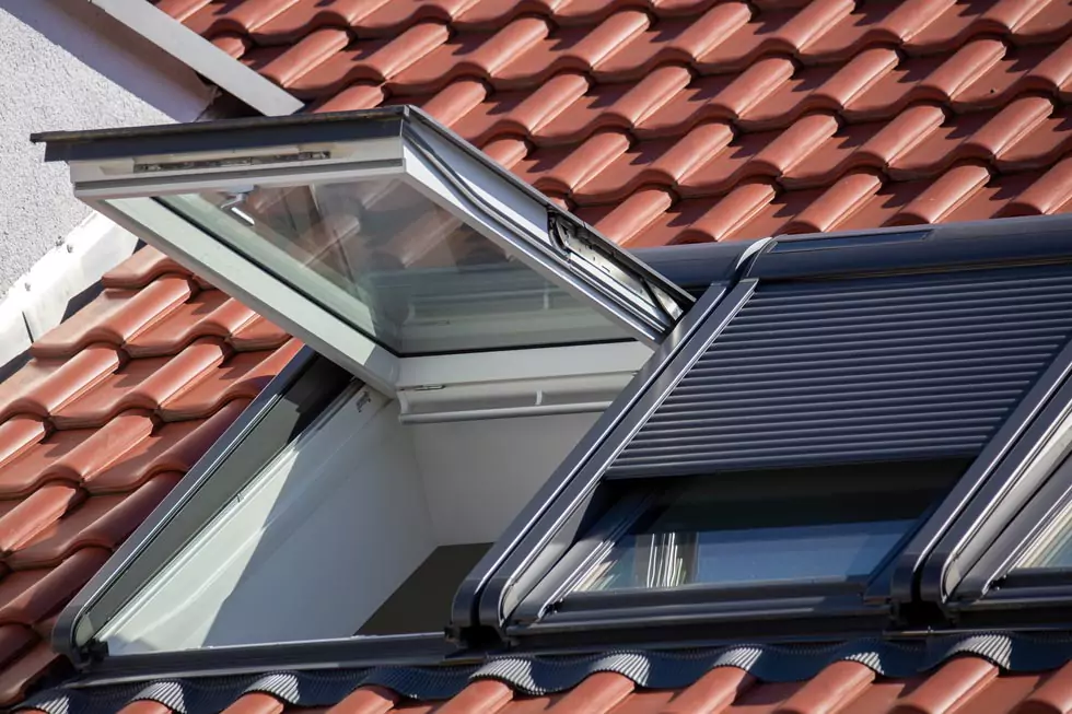 offenes Dachfenster Neue Dachfenster mit Rollläden auf einem roten Ziegeldach